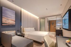 a hotel room with a bed and a tv at Atour Hotel Shenzhen Nanshan West Lizhi Valley Industrial Park in Shenzhen