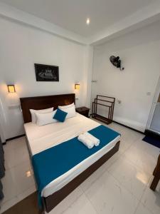 a bedroom with a bed with two towels on it at Devon Surf . Inn - Hiriketiya in Dickwella