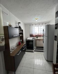 una cocina con refrigerador y encimera en Casa marcius, en Monte Verde