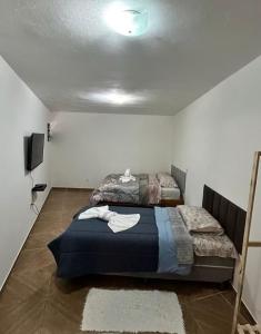 a bedroom with two beds and a tv in it at Casa marcius in Monte Verde