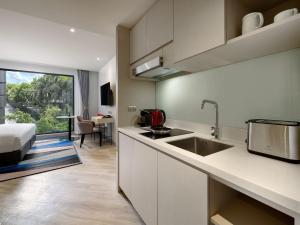 a kitchen with a sink and a bed in a room at Oakwood Studios Sukhumvit Bangkok in Bangkok +77 photos
