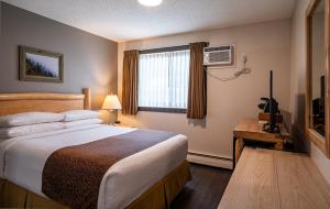 Postel nebo postele na pokoji v ubytování Swiss Chalet Motel