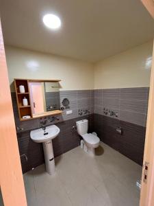 a bathroom with a toilet and a sink at Fyndy Hotel Bir Gandouz in Aousserd +12 photos