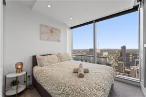 a bedroom with a bed with a teddy bear on it at Brand New 2BR Apt at Mel CBD in Melbourne +17 photos