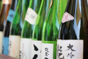 a row of wine bottles with labels on them at Hotel Public Jam in Osaka