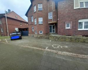 a car parked in a parking lot in front of a brick building at Stadthotel Reckers in Werne an der Lippe