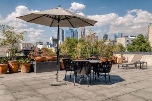 a table and chairs under an umbrella on a patio at Boga Mexico City by Lumina in Mexico City