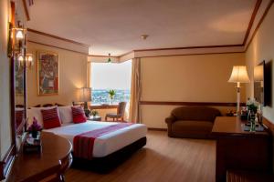 a hotel room with a bed and a couch at Duangtawan Hotel Chiang Mai in Chiang Mai