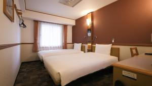 a hotel room with two beds and a window at Toyoko Inn Kanazawa Kenrokuen Korimbo in Kanazawa