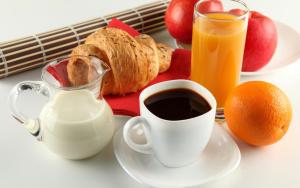 a table with a cup of coffee and a plate of food at Mataireva Lodge TOUR in Arue