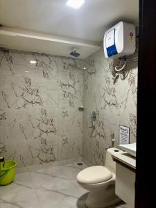 a bathroom with a toilet and a glass shower at Taj Castle Homestay sutable for 17 Peoples in Agra