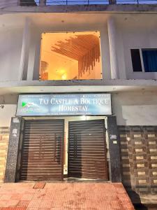 a building with a sign that reads im castle a boutique honesty at Taj Castle Homestay sutable for 17 Peoples in Agra
