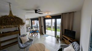 Televiisor ja/või meelelahutuskeskus majutusasutuses SUNSET L'argonaute T3 70 m2 jardin et terrasse vue lagon