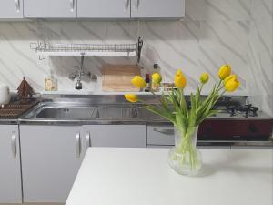 a vase of yellow flowers on a table in a kitchen at Smile Home in Suwon