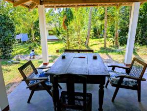 a wooden table and chairs on a patio at Costels Hiriketiya in Hiriketiya