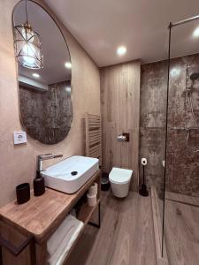 a bathroom with a sink and a toilet and a mirror at Vila Dani in Sinaia +40 photos