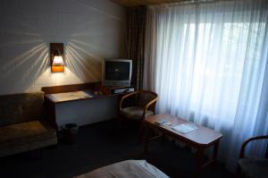a hotel room with a television and a desk with a chair at Zur Rennbahn in Drage