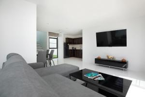カマラビーチにあるNamara The Residences Aのリビングルーム(グレーのソファ、薄型テレビ付)