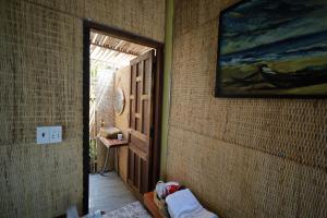 a hallway with a door and a painting on the wall at Hành Ngò Homestay - Hòn Đỏ Ninh Thuận in Thôn Dư Khánh