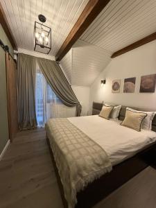 Un dormitorio con una cama grande y una ventana. en Vila Dani, en Sinaia