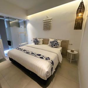 a bedroom with a large bed with blue and white pillows at Little Mykonos in Bandung