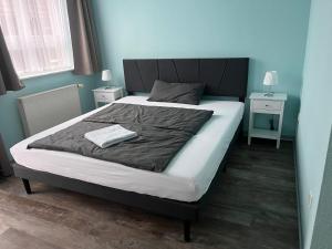 a bedroom with a large bed with a black headboard at Ferienhaus Holzminden in Holzminden