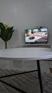 モンバサにあるElegant Studio in Bamburi Fisheriesの白いコーヒーテーブル(壁にテレビ付) +3枚の写真