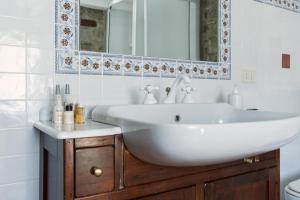 La salle de bains est pourvue d'un lavabo blanc et d'un miroir. dans l'établissement Fattoria Ca' di Fatino, à Castiglione dei Pepoli