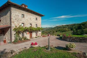 a stone building with flowers in front of it at Fattoria Ca' di Fatino in Castiglione dei Pepoli