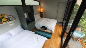 a small room with two beds and a mirror at Wind over Waters Cabin 1 in Pune