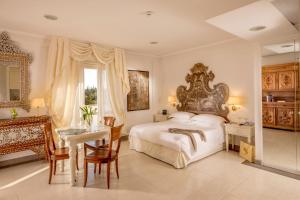 ein Schlafzimmer mit einem großen Bett und einem Tisch und Stühlen in der Unterkunft Arcom Palace in Pomezia