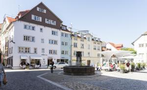 a building with a fountain in the middle of a street at Boutique - Hotel Adara in Lindau