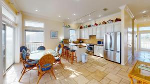 a kitchen with a table and chairs and a refrigerator at Sea Watch-Beachfront-Private Pool-Pet Friendly in St. George Island