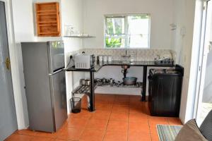 a kitchen with a counter with a sink and a refrigerator at AveBulela Penthouse in Richards Bay