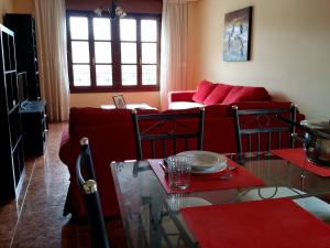 a living room with a red couch and a table at Selgas de Cudillero in Cudillero