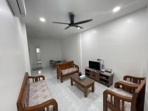 sala de estar con sillas y ventilador de techo en Dhaya Homestay, en Kuantan