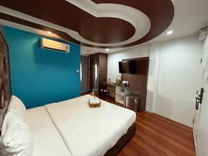 a bedroom with a large bed and a blue wall at Bed By Cruise Hotel At Samakkhi-Tivanont in Nonthaburi