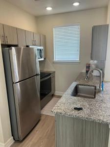 a kitchen with a stainless steel refrigerator and a sink at Chic 1BHK Haven Quiet & Relaxing Near Austin in Cedar Park