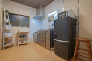 a kitchen with a black refrigerator with a microwave on top at -鳴間の宿 Narumanoyado- Kyoto Aquarium-MUS in Kyoto