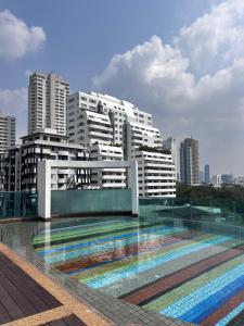 a building with a swimming pool in front of a city at Spacious Sukhumvit Condo near EmQuartier in Bangkok