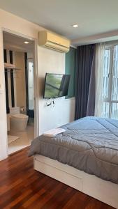 a bedroom with a bed and a flat screen tv at Spacious Sukhumvit Condo near EmQuartier in Bangkok +40 photos