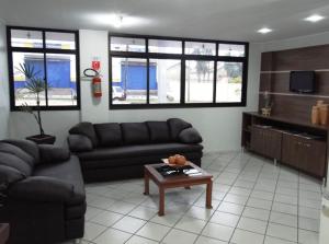 a living room with a couch and a table at Paradise Hotel in Campo Grande