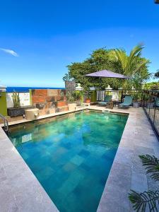 a large swimming pool with blue water at Les palmiers sainte-rose restaurant et chambres in Sainte-Rose