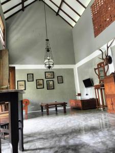 un ampio soggiorno con lampadario a braccio e tavolo di Tempuran Hills Villa Kaliurang Yogyakarta a Kaliurang