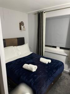 a bedroom with a bed with two towels on it at The Lane Head Hotel in Brighouse +7 photos