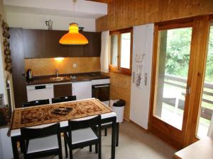 uma cozinha com uma mesa e cadeiras e um lavatório em Apartment in Veysonnaz with Mountain Views em Veysonnaz