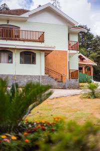 a house with a yard with flowers in front of it at Pousada Vila Floratta in Campos do Jordão