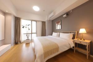 Ліжко або ліжка в номері Shanghai Suju Service Apartment Pudong Wanda Plaza Zhoupu Subway Station Branch