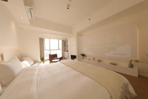 Ліжко або ліжка в номері Shanghai Suju Service Apartment Pudong Wanda Plaza Zhoupu Subway Station Branch