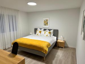 a bedroom with a large bed with a yellow blanket at Dream-Stay I Zentral I cosy I Basel in Pratteln +52 photos